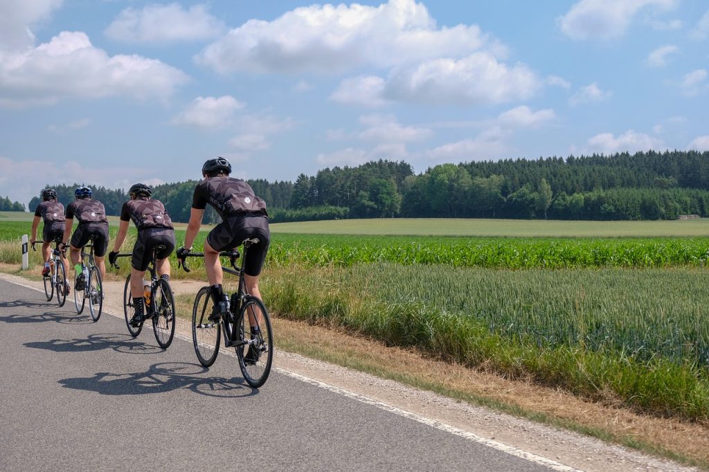 Four cyclists riding together on a country road